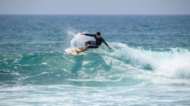 Midigama, Sri Lanka - 03 05 2024: Erkek sörfçü büyük bir kesinti yaparak havaya su püskürttü. Aksiyon dizisi 7-03 'te profesyonel erkek sörfçü.