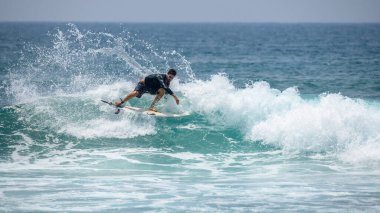 Midigama, Sri Lanka - 03 05 2024: Erkek sörfçü büyük bir kesinti yaparak havaya büyük miktarda su püskürttü. Aksiyon dizisi-7-06 'daki profesyonel erkek sörfçü.