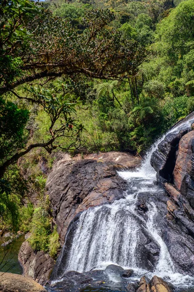 Fırıncının çağlayan şelalesi Horton Plains Ulusal Parkı 'ndaki yoğun yeşil ormanlarla çevrili kayalık kayalıkların üzerinden akıyor..