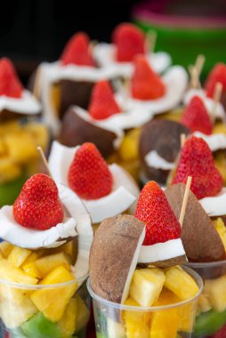 Renkli davet ve taze çilekli meyve salatası, hindistan cevizi, ananas ve kivi.