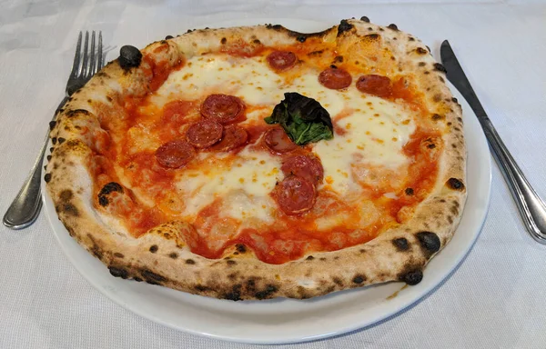 Geleneksel İtalyan ahşabı fırından fırınlanmış baharatlı sosisli pizza (pizza alla diavola)