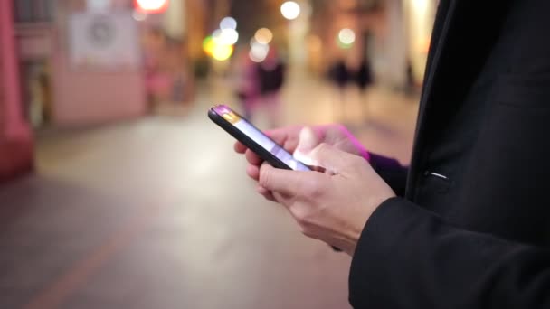 Hombre de pie en una calle de la ciudad y mensajes de texto rápido en el teléfono inteligente — Vídeo de stock