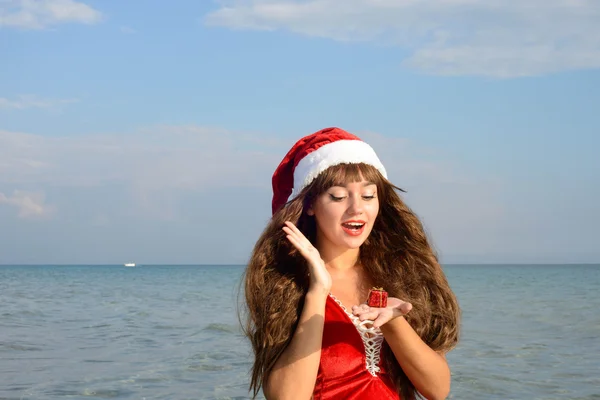 Happy and beautiful girl Santa Claus on the beach. — Stock Photo, Image