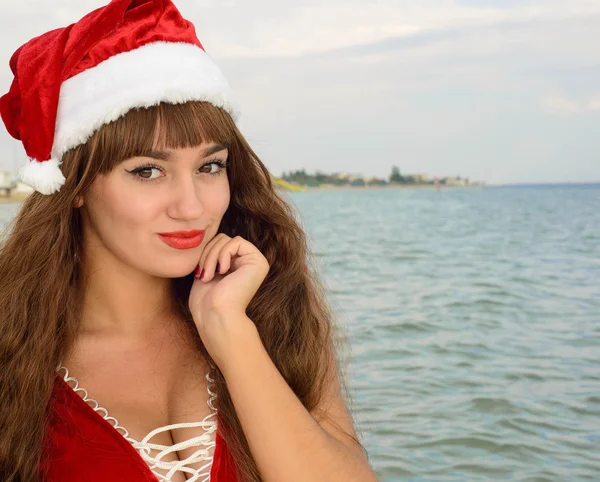 Fată fericită și frumoasă Moș Crăciun pe plajă . — Fotografie, imagine de stoc