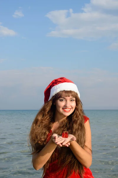 Happy and beautiful girl Santa Claus on the beach. — Stock Photo, Image