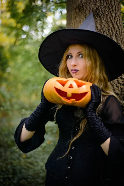 Halloween, fille en robe de sorcière avec citrouille — Photo