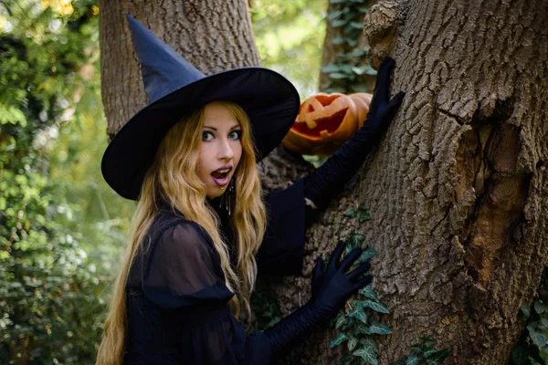 Halloween, fille en robe de sorcière avec citrouille — Photo