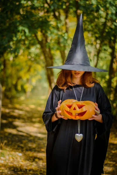 Halloween, fille en robe de sorcière avec citrouille — Photo