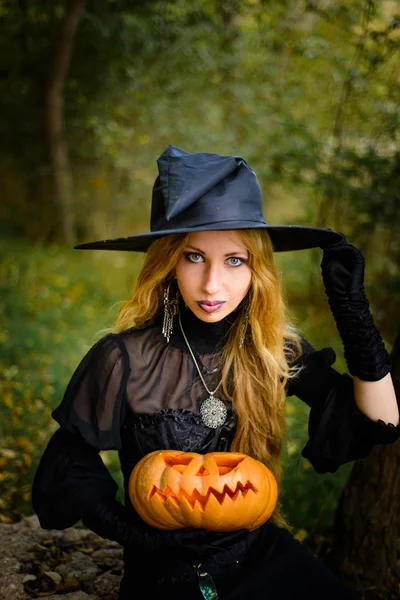 Halloween, fille en robe de sorcière avec citrouille — Photo