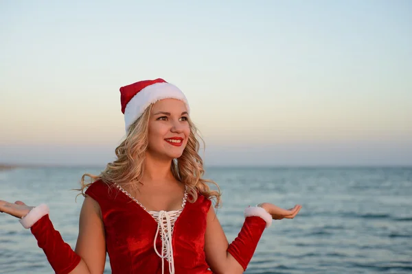 美丽的女孩圣诞老人在海滩上 — 图库照片