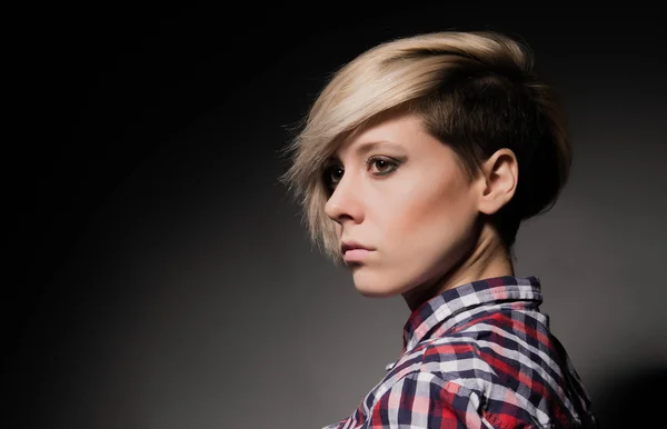 Blondes Mädchen mit kurzem stylischem Haarschnitt auf dunklem Hintergrund — Stockfoto