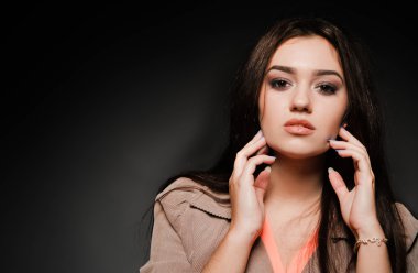 Karanlık bir arka plan üzerinde uzun saçlı güzel esmer