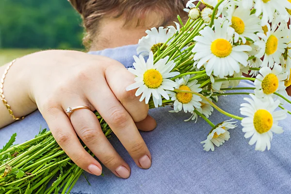 Close up of arm with bouquet chamomile. — Stock Photo, Image