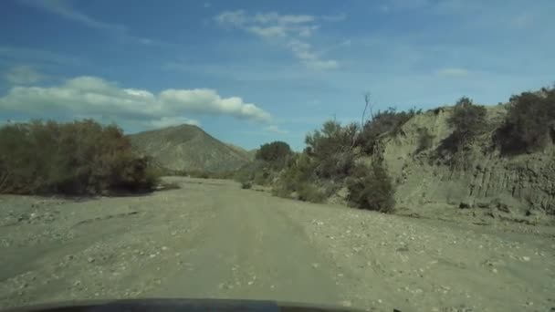 Offroad w Desierto De Tabernas, Andaluzja, Hiszpania, nakręcony przez szybę przednią z odbicia — Wideo stockowe