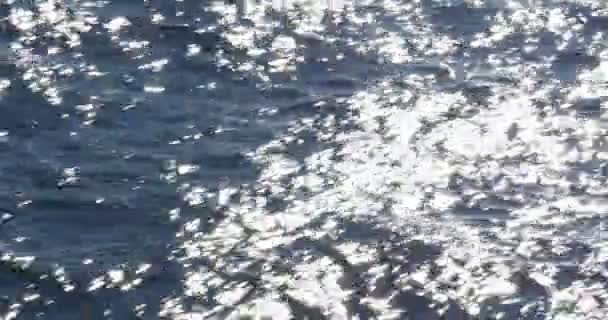 Flying over the ocean, waves forming, sparkles and wakes — Stock Video