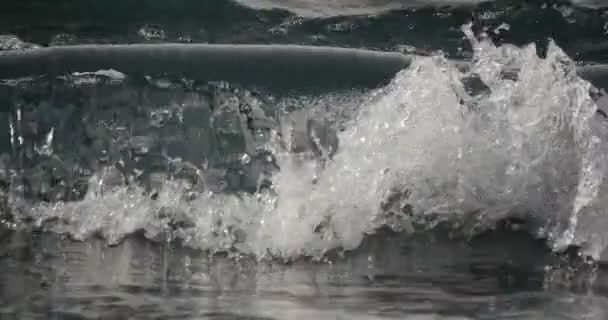 4K, драматичные волны воды, плещущиеся и ударяющиеся о камни — стоковое видео
