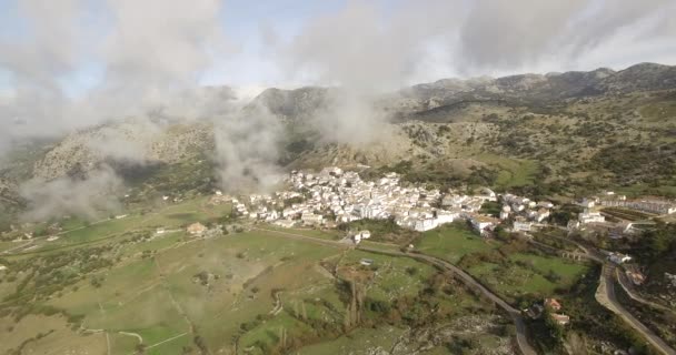 Vuelo aéreo 4K sobre pueblo andaluz rodeado de enormes montañas en España — Vídeo de stock