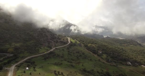 Vuelo aéreo 4K sobre pueblo andaluz rodeado de enormes montañas en España — Vídeos de Stock