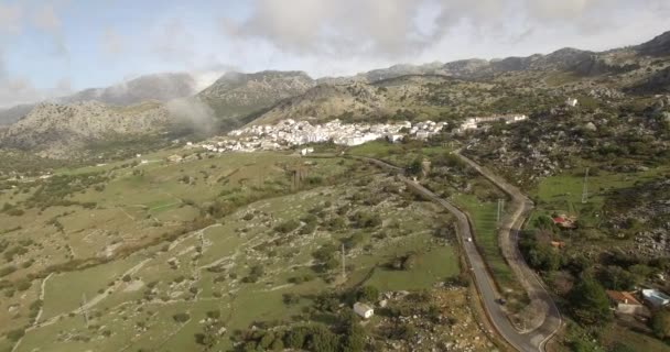 Vuelo aéreo 4K sobre pueblo andaluz rodeado de enormes montañas en España — Vídeos de Stock