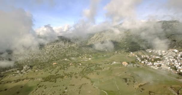 Vuelo aéreo 4K sobre pueblo andaluz rodeado de enormes montañas en España — Vídeos de Stock