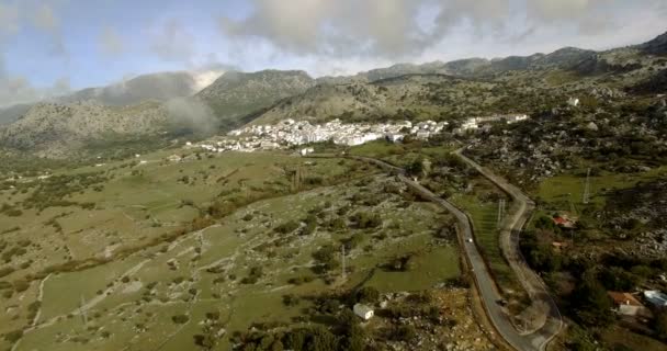 Vuelo aéreo 4K sobre pueblo andaluz rodeado de enormes montañas en España — Vídeos de Stock