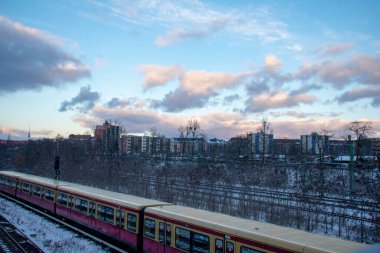 Schoneberg Berlin 'deki karlı tren raylarında giden S bahn treni.