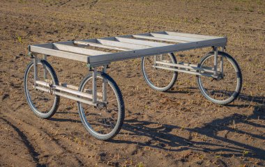 Tarım arabası, bisiklet büyüklüğünde tekerlekler üzerinde oturan düz bir bank. Yazın Kanazawa, Japonya 'da tarlada gibi..