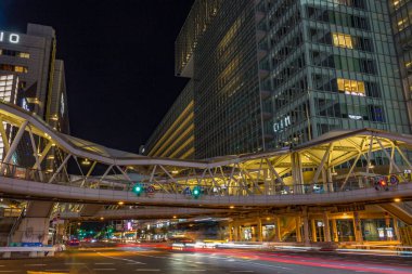 Japonya 'nın Osaka kentindeki Tennoji bölgesinin gece görüşü, hareket halindeki araçların yaya köprüsünü ve ışık yollarını gösteriyor..