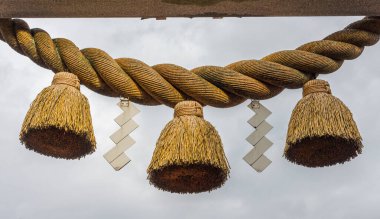 Kutsal halat, ya da Shimenawa, ve zigzag flamalar, ya da kalkan, Torii kapısı üzerinde küçük yerel tapınak, Kumagawa, Japonya.
