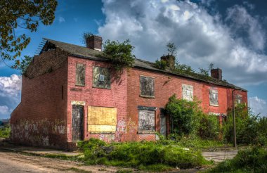 Pencereleri tahtayla kapatılmış yıkım bekleyen terk edilmiş teraslı evler. Clayton, Manchester İngiltere.