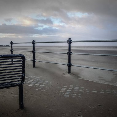 Kıyı yolu, ıssız, bank, trabzan ve rüzgarlı kum, New Brighton, İngiltere.