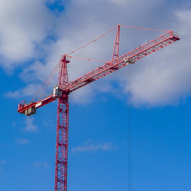 Kırmızı vinç mavi gökyüzüne karşı, Manchester, İngiltere. Manchester İşletme Fakültesi 'nin yeni otelinin inşaatı.