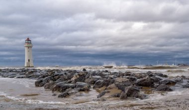 New Brighton 'daki deniz feneri, Merseyside, İngiltere, fırtınalı denizde. Ayrıca Perch Rock Deniz Feneri olarak da bilinir, 1827 yılında inşa edilmiş ve 1973 yılında kapatılmıştır. Listede adı geçen ikinci sınıf bir bina..
