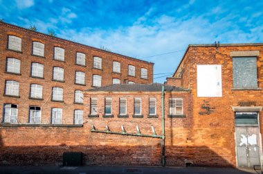 Eski tesisat boruları ve pencereleri, Stockport, Cheshire, İngiltere 'deki terk edilmiş sanayi binaları..