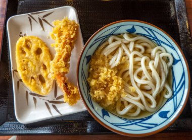 Kanazawa, Ishikawa Bölgesi, Japonya 'da bir tabak karides ve nilüfer kökü (renkon) tempura ile birlikte, Dashi çorbasında bir tabak Udon eriştesi..