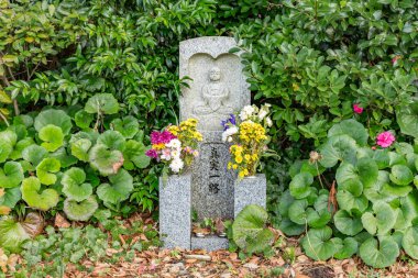 Japonya 'nın Ishikawa kentindeki Daijouji Tapınağı' nda, çocukların koruyucusu ve koruyucusu Jizou san 'ın çiçekli küçük taş heykeli. TEXT 'in TÜRKÇE: gerçeği ile doğru bir yol izleyin.