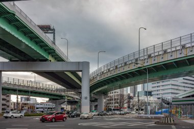 Sokak seviyesindeki trafik ve tepedeki büyük beton otobanlardan görüntü. Nagoya, Japonya.