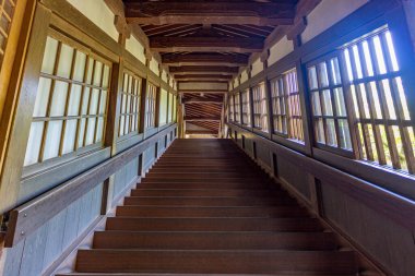 Dik ahşap merdiven ve pencerelerden içeri ışık sızıyor, Eiheiji, Japonya.