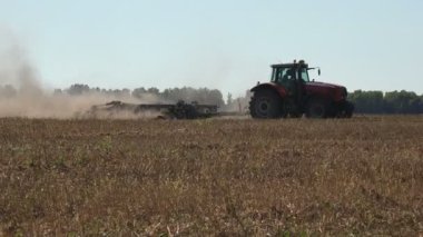 Büyük dumanlar. Traktör, tohumu kuru siyah toprakla sürüyor. Büyük bir tarlada buğday yetiştiriyor. 