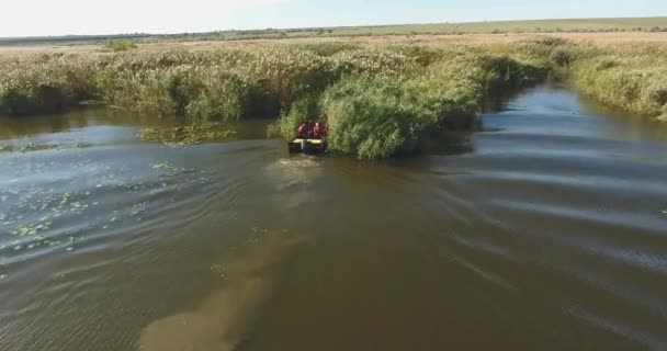 空中风景 载有渔民的汽船沿着秋天的河流快速漂流 撞入干枯的芦苇中 — 图库视频影像
