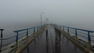 Sabah erkenden. Sis. Bisikletle nehirden geçen yayalar için yürüyen metal köprü