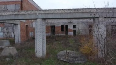 Yıkık ve bitmemiş bir binanın tuğla duvarındaki pencere ve kapıların açılışını görmek. Eski terk edilmiş bina