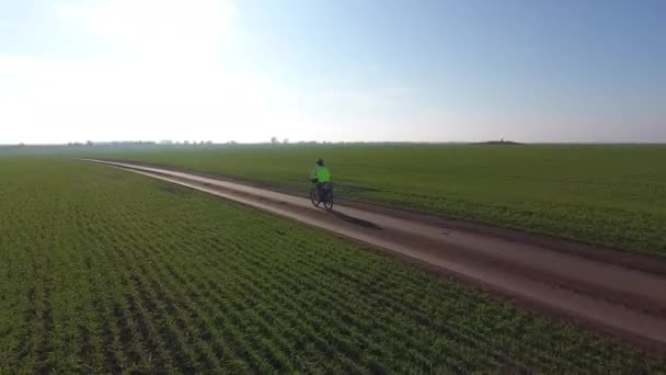 绿色农田中的空旷 骑自行车 骑自行车的人 — 图库视频影像