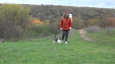 Cat, metresiyle sonbahar dağlarının arasında yürürken, doğrudan yeşil çimenlerdeki kameraya gider.