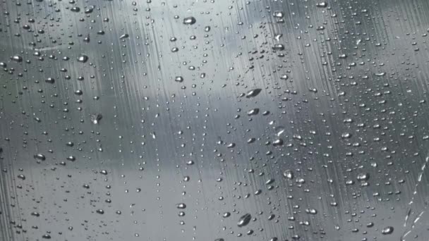 Gouttelettes d'eau de pluie sur verre coulent vers le bas macro — Video