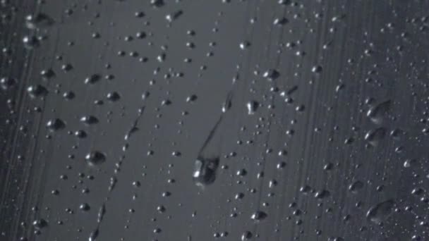 Wassertröpfchen aus Regen auf Glas fließen Makro hinunter — Stockvideo