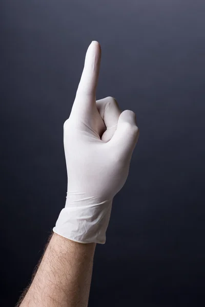 Masculino mão na luva de látex apontando para cima — Fotografia de Stock