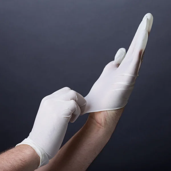 Putting on latex gloves — Stock Photo, Image