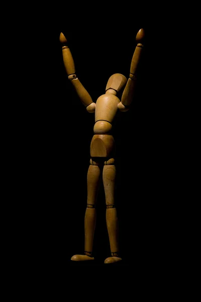 Wooden mannequin raising hands to light isolated on black. — Stock Photo, Image
