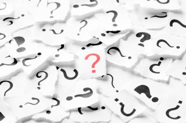 Ortasında kırmızı bir sembol olan soru işaretleri yığını. Karar, soruşturma veya faq kavramı.